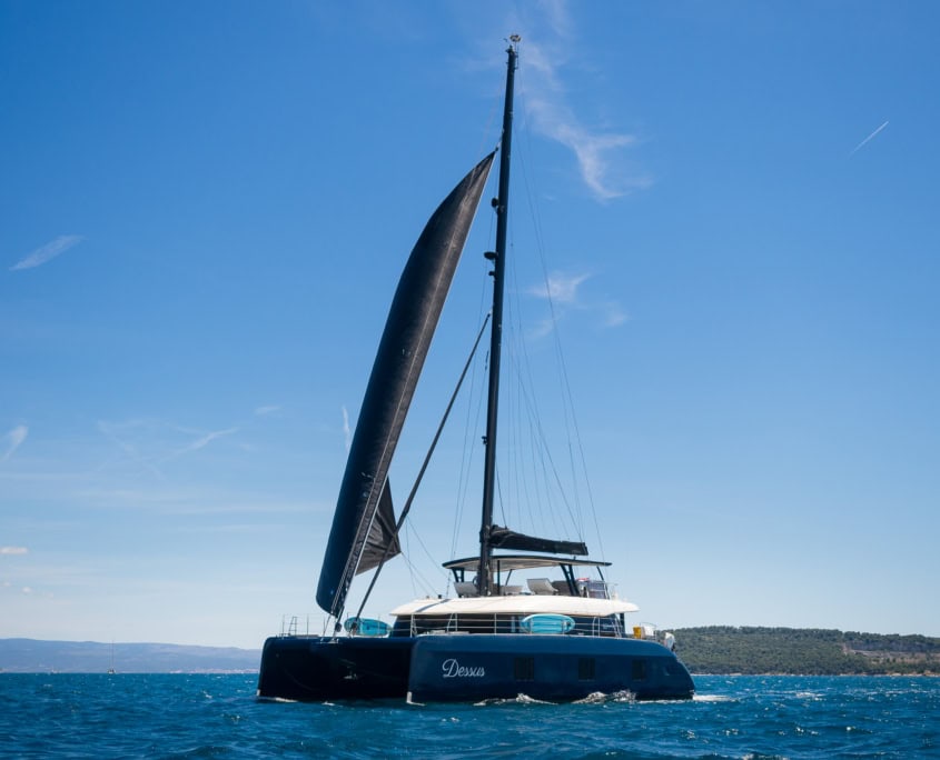 Luxury sailing yacht on clear blue waters under a bright sky.
