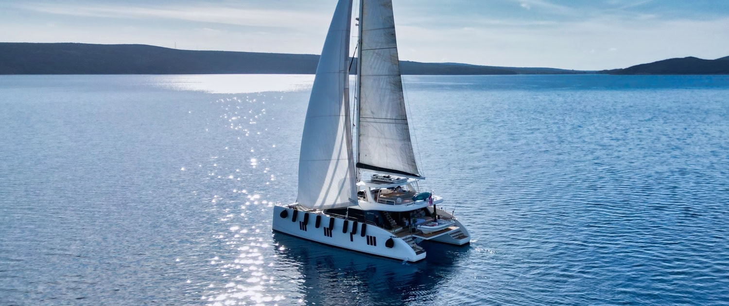 Luxury Sunreef 80 sailing yacht on calm blue waters.