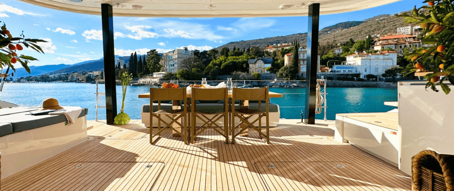Luxury Sunreef 80 sailing yacht deck overlooking a scenic coastal landscape.